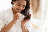 istock African American Woman Applying Serum On Damaged Hair In Bathroom 1322880152