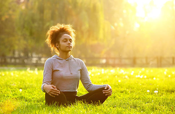 African american woman meditating in nature stock photo