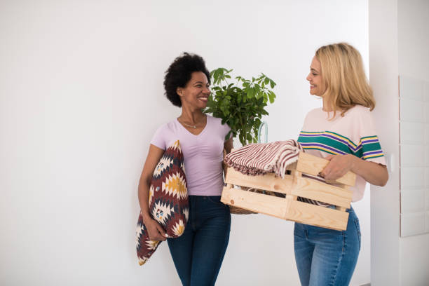 African American woman moving in and showing the new apartment to her friend stock photo