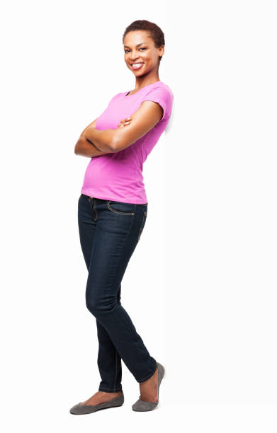 African American Woman Standing With Arms Crossed - Isolated Full length portrait of an African American woman standing with arms crossed in casuals. Vertical shot. Isolated on white. leaning stock pictures, royalty-free photos & images