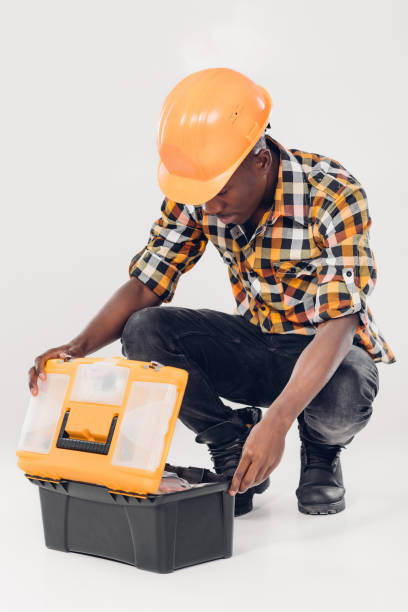 African American worker with tool box African American construction worker in helmet takes out tools from yellow plastic tool box african american plumber stock pictures, royalty-free photos & images