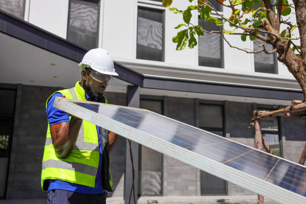 African American worker working on installing solar panel on the rooftop of the house for renewable energy and environmental friendly outcome stock photo