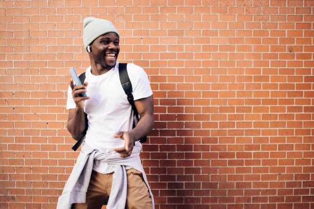 African American young man on vacation enjoying music on the street stock photo