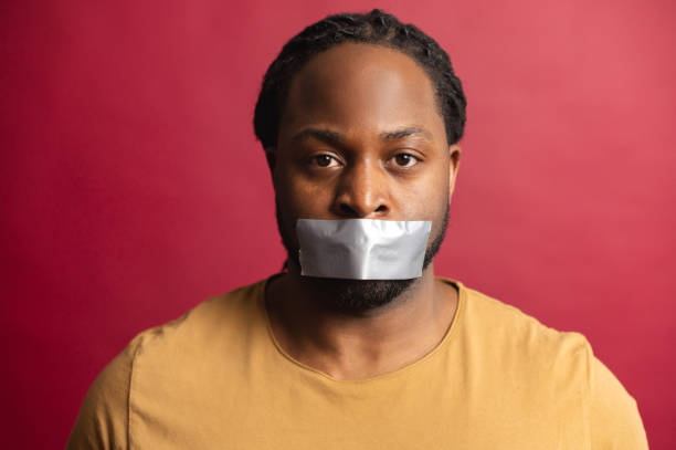 afrikaanse boze mens met zijn mond die met band wordt verzegeld - plakband mond stockfoto's en -beelden