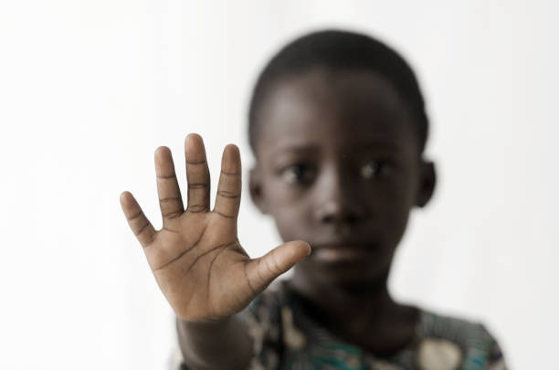 African boy makes a STOP sign with his hand, isolated on white stock photo