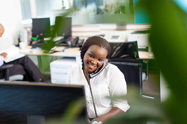 African business women smiling, having a telephone conversation stock photo