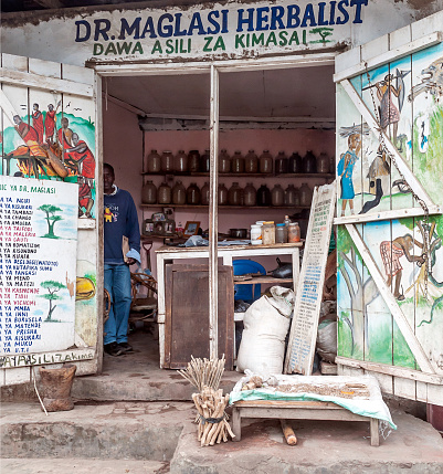 ARUSHA, TANZANIA - OCTOBER 21, 2014 : Typical street scene in Arusha. Arusha is located below Mount Meru in the eastern branch of the Great Rift Valley and the capital of the Arusha Region. You can see a poor clinic for african people.