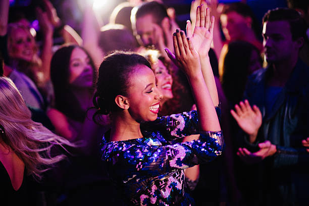 African descent girl enjoys dancing with friends in nigh club African descent young girl enjoys dancing with her friends in a nigh club entertainment club stock pictures, royalty-free photos & images