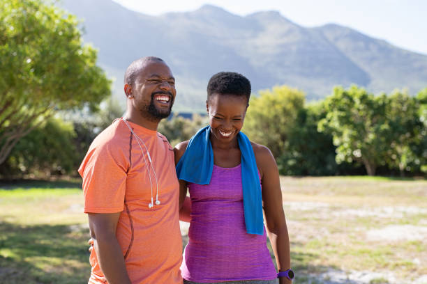 afrikaanse fitness volwassen paar lachen op park - train travel stockfoto's en -beelden