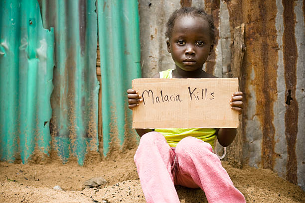 african girl holding sign with "malaria kills" written on it - malaria stockfoto's en -beelden