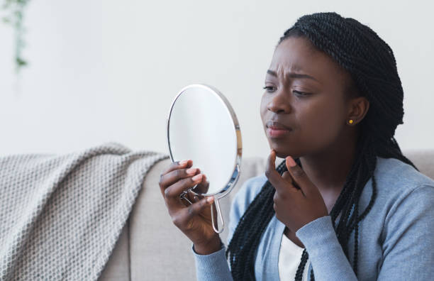 fille africaine regardant dans le miroir rond et touchant son menton - round mirror photos et images de collection