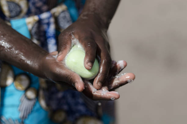 African Girl Washing Hands with Soap and Water stock photo
