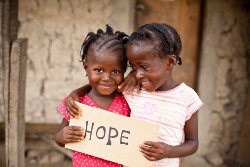 Two African girls holding a sign with 