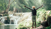 istock African man traveler standing on the water fall  with smile and happy.16:9 style 1325190758