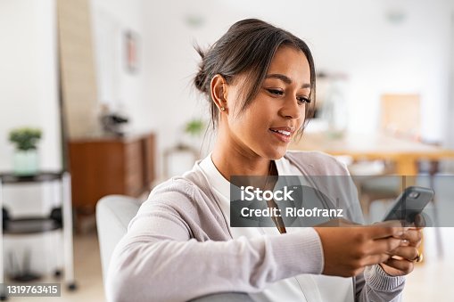 istock African mid woman using smartphone at home 1319763415