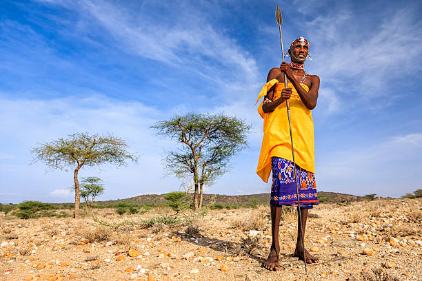 African warrior from Samburu tribe, central Kenya, East Africa African warrior from Samburu tribe standing on savanna and holding a spear, central Kenya. Samburu tribe is one of the biggest tribes of north-central Kenya, and they are related to the Maasai. masai warrior stock pictures, royalty-free photos & images