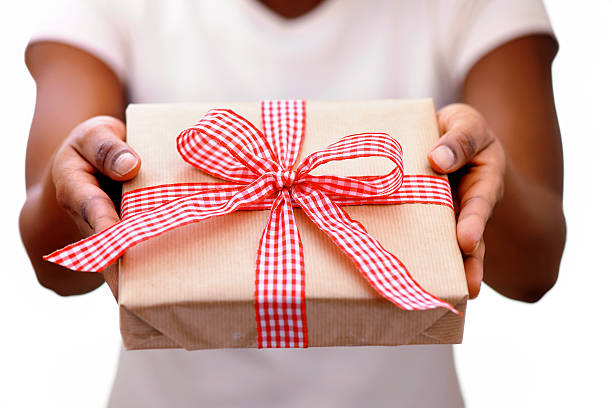 African woman giving a christmas present stock photo