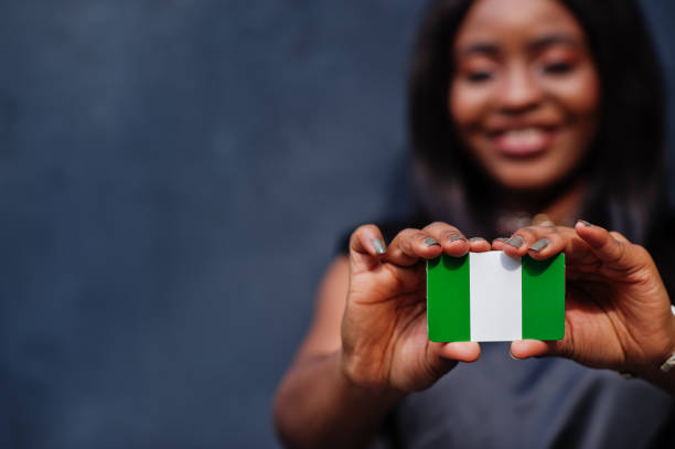 아프리카 여성이 작은 나이지리아 국기를 손에 들고 있다. - nigeria 뉴스 사진 이미지