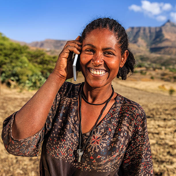 африканская женщина с помощью мобильного телефона, деревня возле лалибела, ...