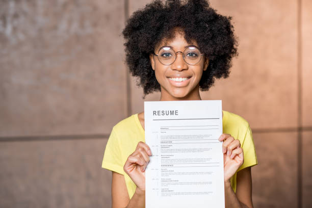 African woman with resume Portrait of a young african woman holding resume document indoors resume stock pictures, royalty-free photos & images