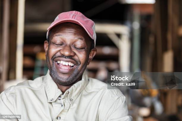African-American man at lumberyard wearing trucker's hat