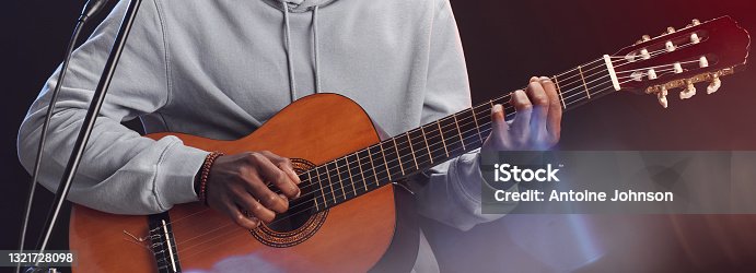 istock African-American Man Playing Guitar on Stage 1321728098