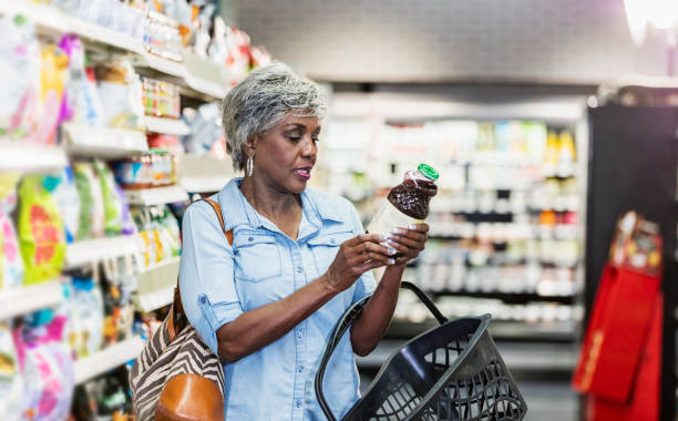afroamerikansk kvinna i dagligvaruhandeln läs etikett - food labels bildbanksfoton och bilder