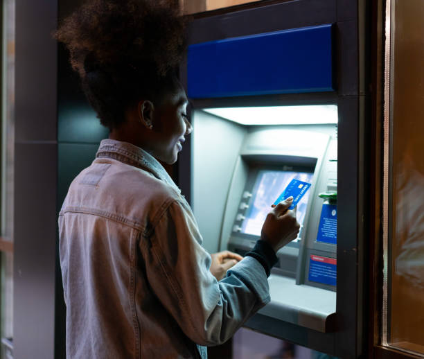 Afro American woman withdrawing money at the ATM Afro American woman withdrawing money at the ATM banks and atms stock pictures, royalty-free photos & images