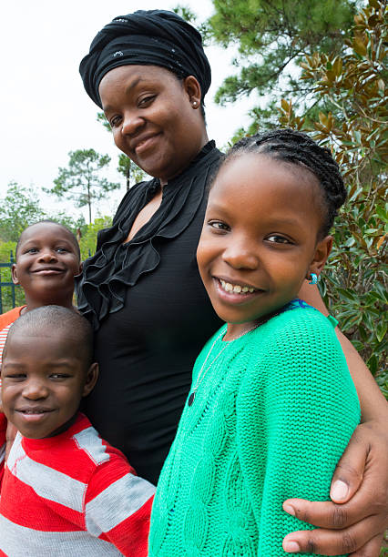 Afro caribbean family Afro caribbean mature woman posing with her three kids looking at the camera beautiful haitian women stock pictures, royalty-free photos & images