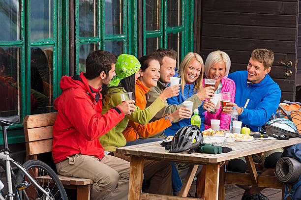After biking young friends drinking beverage stock photo