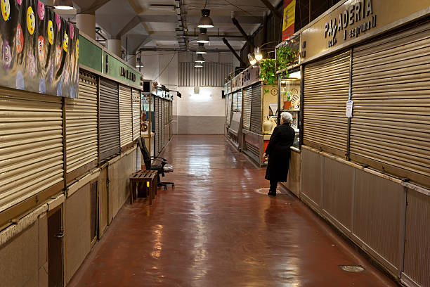 after hours "Madrid, Spain - April 2, 2013: closing time in a Spanish market hall - old lady having a chat with a booth owner - most stalls are already closed" madridshop stock pictures, royalty-free photos & images
