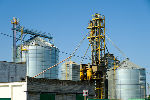 Agricultural Silos. Storage tanks agricultural crops processing plant. Granary elevator. Agribusiness concept.