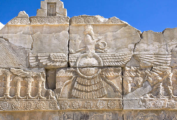 Ahura Mazda - relief of ruined Persepolis Faravahar - relief of winged sun symbol of Zoroastrianism in Persepolis city, Iran. Persepolis was a capital of the Achaemenid Empire, 550 - 330 BC. mesopotamian stock pictures, royalty-free photos & images