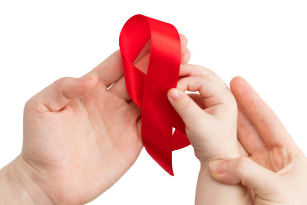 Aids red ribbon on woman's and child's hands support for World aids day stock photo