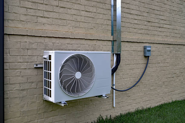 Air Conditioner mini split system next to home with brick wall stock photo