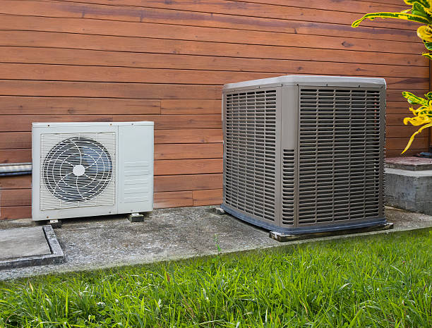 Air conditioning heat pumps Air conditioning heat pumps on the side of a house oil pump stock pictures, royalty-free photos & images