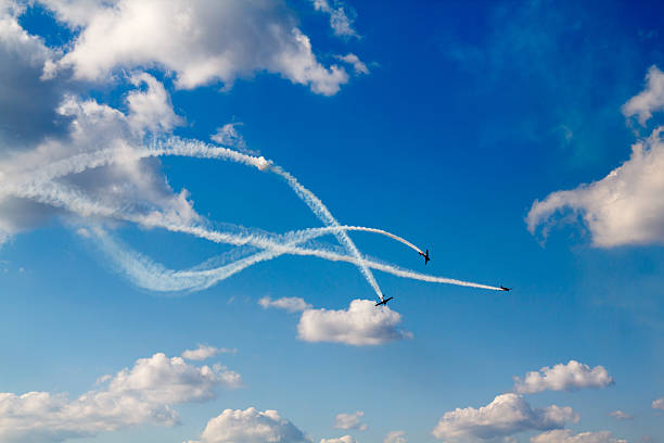 air dogfight on airshow flight of 3 planes with intersecting trails airshow stock pictures, royalty-free photos & images