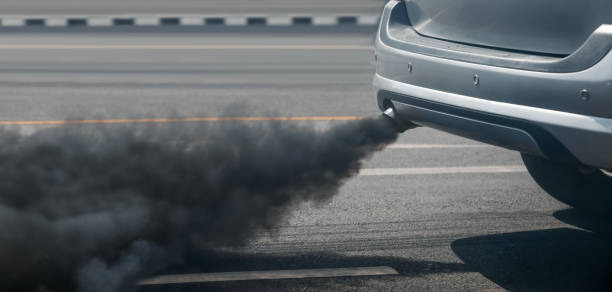 air pollution crisis in city from diesel vehicle exhaust pipe on road stock photo