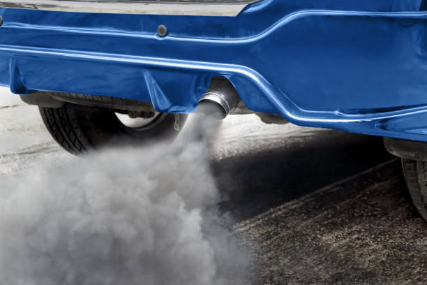 Air pollution from vehicle exhaust pipe on road stock photo