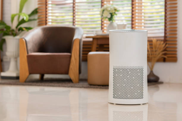 Air purifier in cozy white living room for filter and cleaning removing dust PM2.5 HEPA and virus in home,for fresh air and healthy Wellness life,Air Pollution Concept stock photo