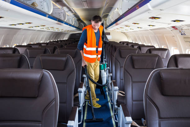 Aircraft cleaning service. Man cleaner working in airplane salon stock photo