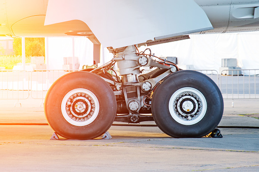 Aircraft rear landing gear with wheels and rubber, side view.