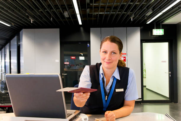 Airline Employee handing Ticket and Passport to Customer stock photo