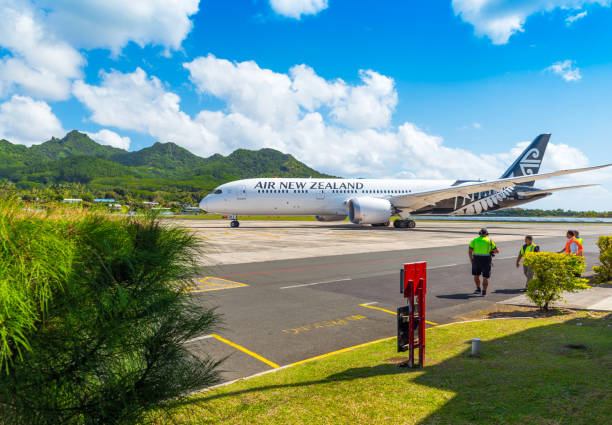 самолет в аэропорту на фоне горного пейзажа. с выборочным фокусом - cook islands стоковые фото и изображения