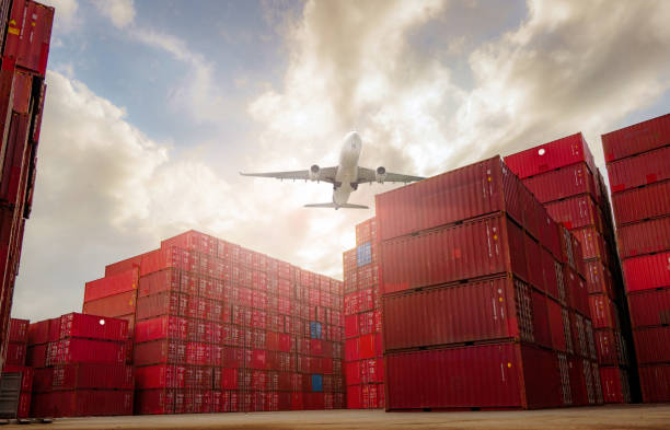 Airplane flying above container logistic. Container crisis. Freight transportation. Logistic industry. Container ship for export logistics. Container at the harbor for truck transport. Air transport. stock photo