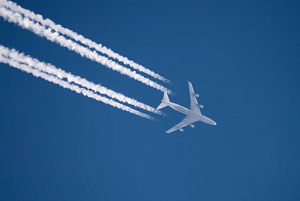 Airplane flying in high altitude leaving contrail Airplane flying in high altitude leaving contrails. Photo taken in Duesseldorf, Germany. Distance is approx. 33000ft / 10000m. vapor trail stock pictures, royalty-free photos & images