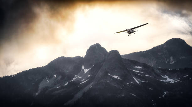 Airplane flying near the Beautiful Canadian Mountain Nature Landscape stock photo