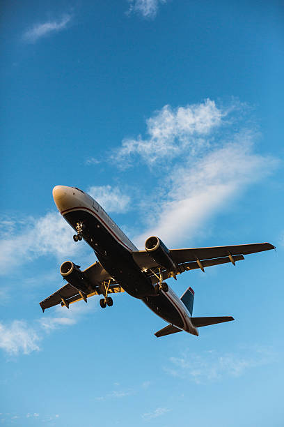 Airplane flying with blue sky in background stock photo