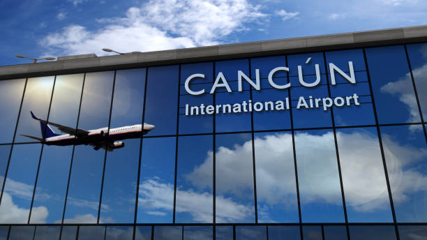 Airplane landing at Cancún Mexico mirrored in terminal stock photo