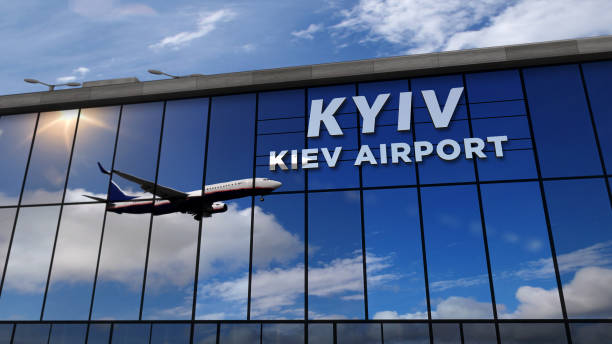 Airplane landing at Kiev mirrored in terminal stock photo